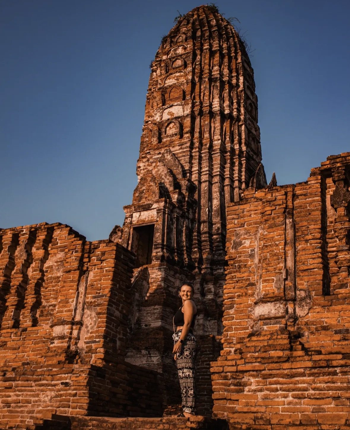 Visitor with day pack and camera exploring temple ruins on Ayutthaya Historical Park Tours